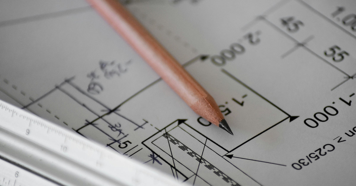 a pencil lays on architecture plans